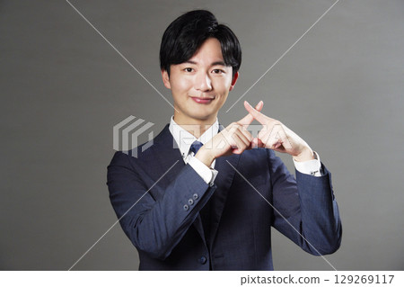商人在黑色背景上做十字手勢 129269117