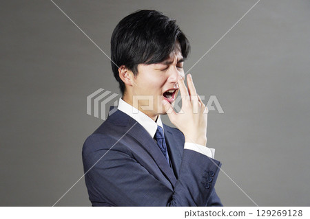 Businessman yawning black background 129269128