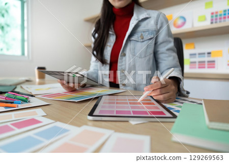 Creative woman working with color swatches and digital tools 129269563