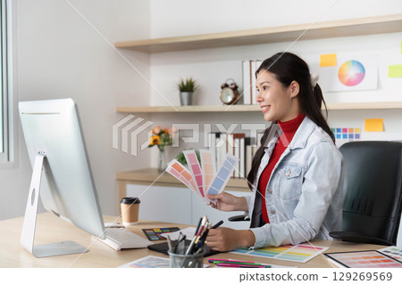 Young woman selecting color swatches while working on design 129269569