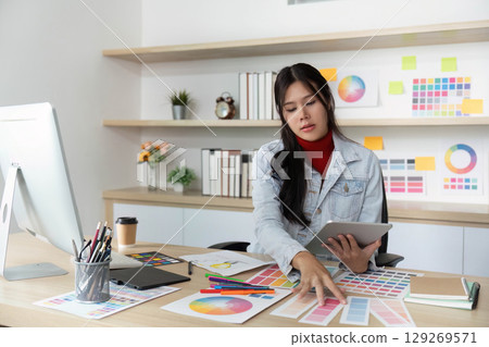 Creative Designer Discussing Color Options in Bright Office 129269571