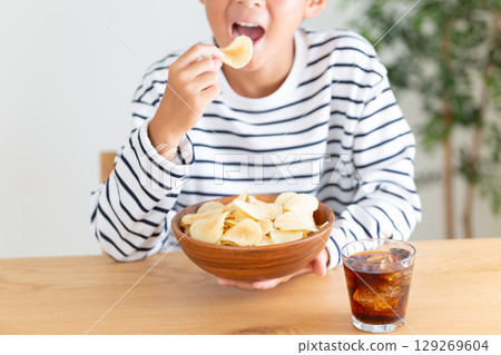 Elementary school boy eating sweets 129269604