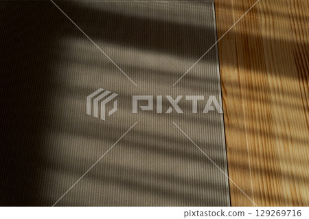 The shadow of the blinds is reflected on the floor 129269716