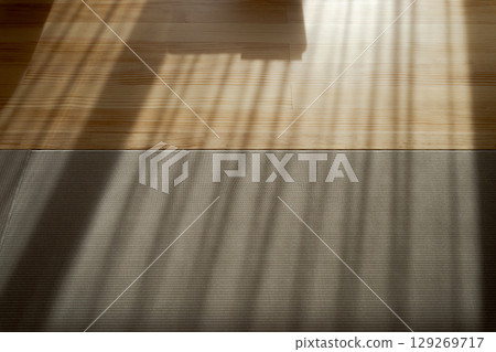 The shadow of the blinds is reflected on the floor The shadow of the blinds is reflected on the floor 129269717