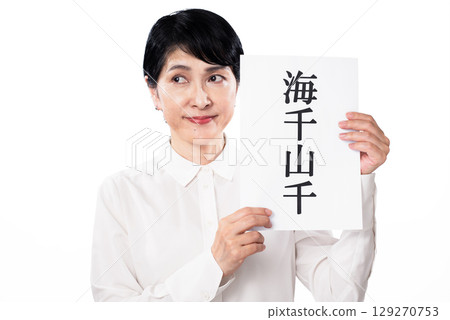 一位中年婦女拿著一張寫著「海洋」的紙條看著它 129270753