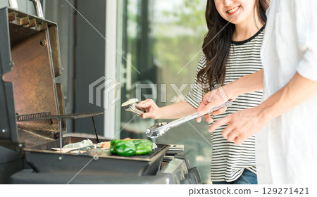 Men and women having barbecue, camping, BBQ, grilled meat, glamping (home party, balcony camping) 129271421