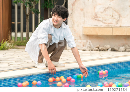 年輕的亞洲男子在度假勝地的泳池畔玩耍 129271584