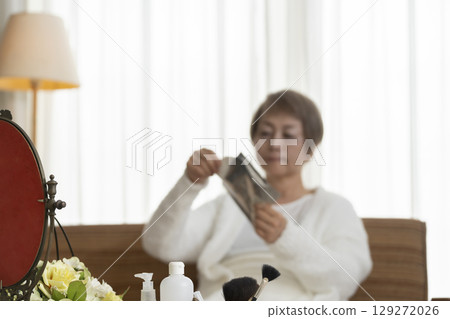 Senior woman taking care of her skin with a face mask Senior woman taking care of her skin with a face mask 129272026