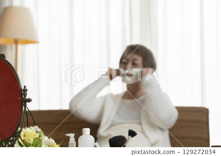 一位老年婦女戴著面膜護理皮膚 一位老年婦女戴著面膜護理皮膚 129272034