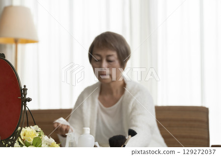 Senior woman taking care of her skin with a face mask Senior woman taking care of her skin with a face mask 129272037