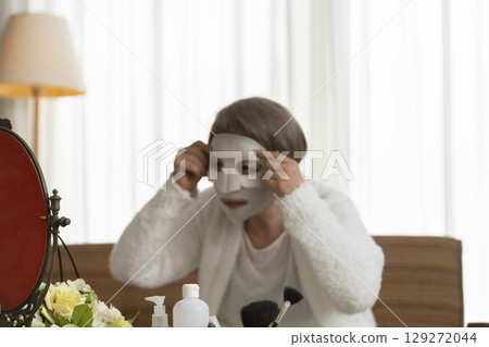 Senior woman taking care of her skin with a face mask Senior woman taking care of her skin with a face mask 129272044
