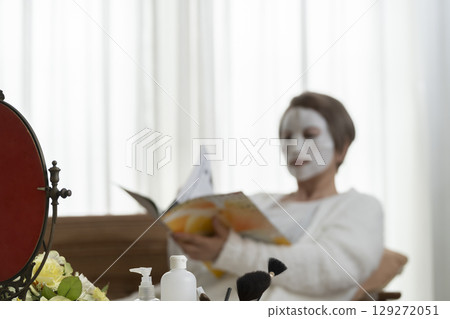 Senior woman taking care of her skin with a face mask 129272051