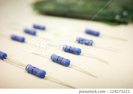 Blue Axial Resistors on White Background Electronic Components Close-Up 129273221
