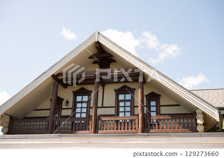 Wooden cabin exterior with gabled roof and sky background Wooden cabin exterior with gabled roof and sky background 129273660