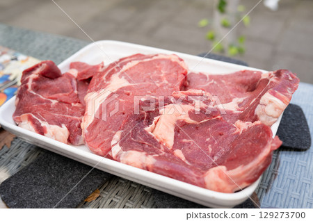 Fresh raw beef steaks on white tray outdoor setting 129273700