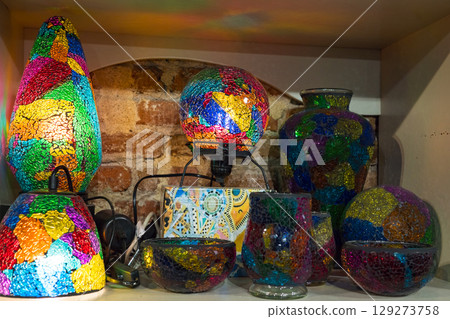 Colorful mosaic glass lamps and vases on rustic shelf Colorful mosaic glass lamps and vases on rustic shelf 129273758