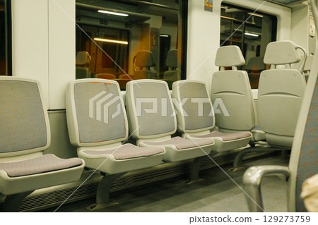 Empty train interior with gray seats at night Empty train interior with gray seats at night 129273759