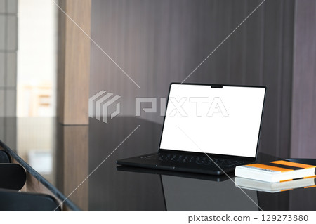 Modern workspace with a sleek black laptop on a glossy desk 129273880