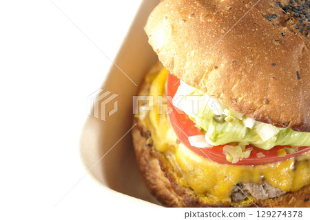 A hamburger topped with cheddar cheese photographed on a white background A hamburger topped with cheddar cheese photographed on a white background 129274378