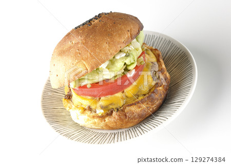 白色背景下拍攝的漢堡,上面鋪著切達起司 白色背景下拍攝的漢堡,上面鋪著切達起司 129274384