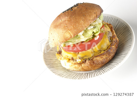 白色背景下拍攝的漢堡，上面鋪著切達起司 129274387