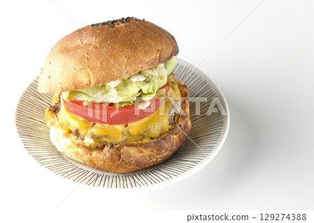 白色背景下拍攝的漢堡，上面鋪著切達起司 129274388