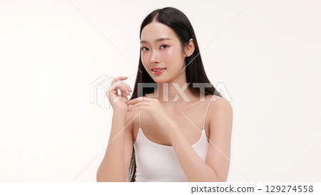 Skincare commercial of featuring a young Asian woman applying natural cosmetic cream in a soft, minimal studio setting. Ideal for promoting beauty, self-care, and organic skincare products. Skincare commercial of featuring a young Asian woman applying natural cosmetic cream in a soft, minimal studio setting. Ideal for promoting beauty, self-care, and organic skincare products. 129274558