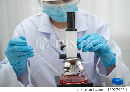 Scientist medical professional use microscope for research in science laboratory. 129274914