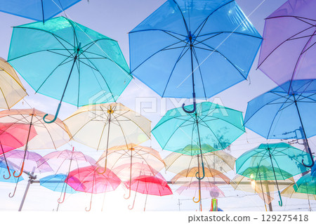 陽光明媚的夏日,五顏六色的傘覆蓋著傍晚的天空。 陽光明媚的夏日,五顏六色的傘覆蓋著傍晚的天空。 129275418