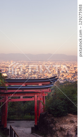 Torii gate overlooking Kyoto from Mount Inari at sunrise captured from Fushimi Inari Taisha trail Torii gate overlooking Kyoto from Mount Inari at sunrise captured from Fushimi Inari Taisha trail 129275988