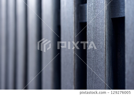 Detailed texture of aligned wooden boards in dark tones captured with shallow depth 129276005