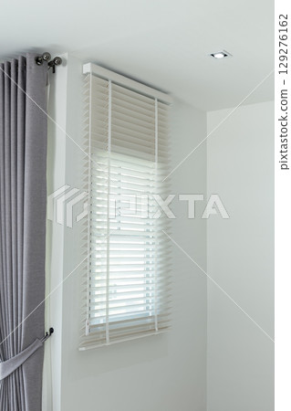 Sun-blocking blinds are hung on the windows. 129276162