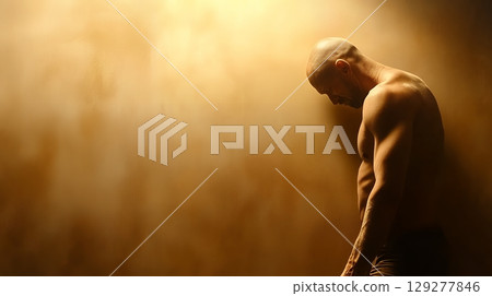 A shirtless man stands pensively against a textured wall, dramatically lit, creating a moody and introspective atmosphere A shirtless man stands pensively against a textured wall, dramatically lit, creating a moody and introspective atmosphere 129277846