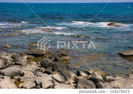 beautiful landscape on the coast of the beach and sea waves against the background of the blue sky 129278025