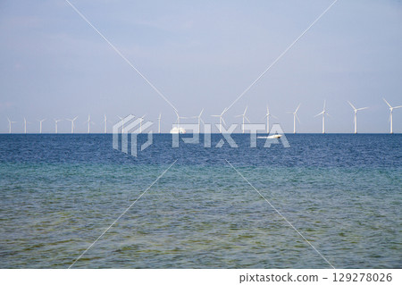 many windmills standing in the sea generate electricity 129278026
