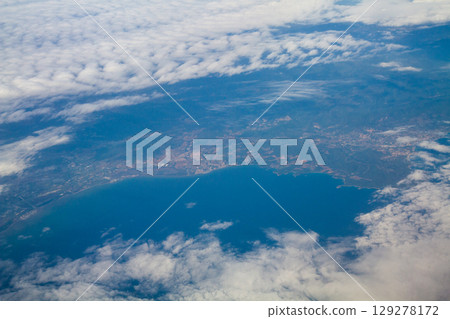 beautiful thick clouds in the sky from the height of the flight of the plane with a view of the continent and countries 129278172