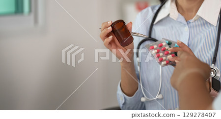 Patient Consultation. Doctor discussing medication with a patient in a clinical setting. 129278407