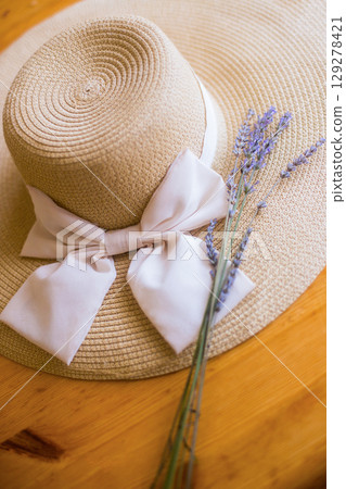 a woman's straw hat and a bouquet of lavender flowers 129278421