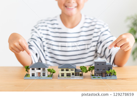 Elementary school boy pointing at a model of a house 129278659