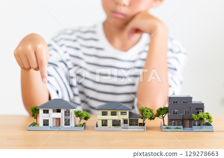 Elementary school boy worried about a house model Elementary school boy worried about a house model 129278663