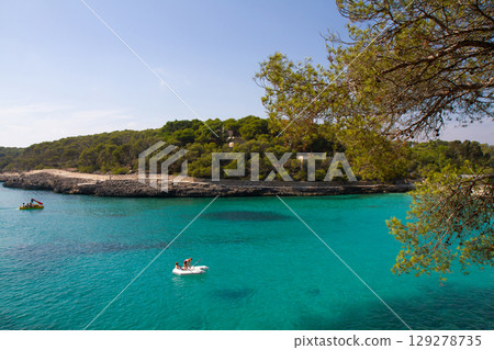 people are sailing on an inflatable boat in a beautiful clear sea people are sailing on an inflatable boat in a beautiful clear sea 129278735