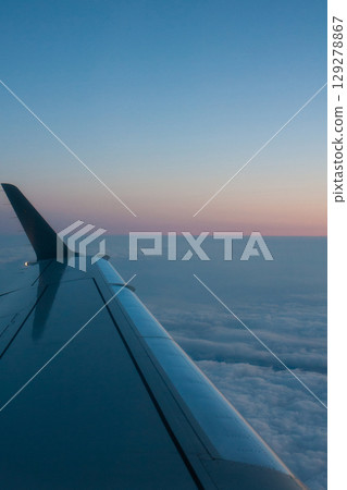 beautiful thick clouds in the sky from the height of the flight of the plane with a view of the wing with engines 129278867