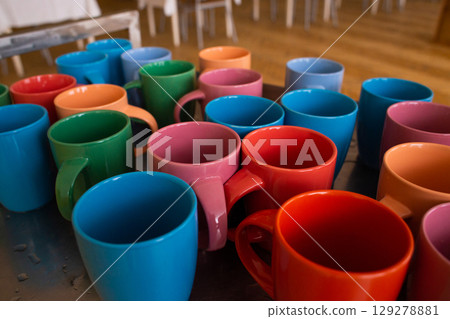 many colorful cups on the table in the dining room 129278881
