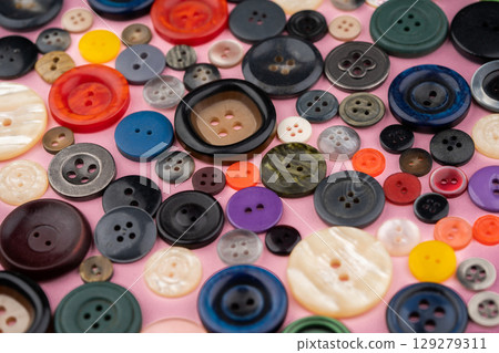 Many different buttons on a pink background 129279311
