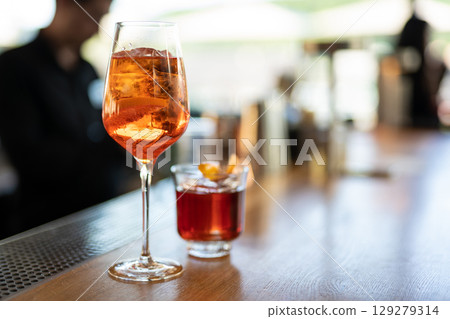 the bartender prepares a beautiful alcoholic cocktail at the bar counter 129279314