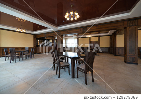 spacious interior of modern empty large restaurant with tables and chairs. 129279369