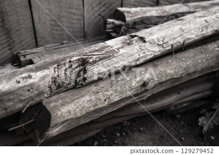 black and white photo of old wooden boards stacked in the backyard 129279452