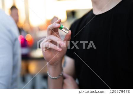holding small glass jars with different scents in their hands 129279478