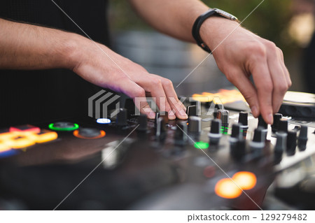 a DJ plays music on a controller at a party 129279482