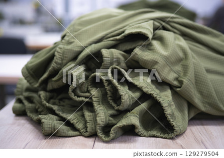 a pile of sewn heat sink clothes on a table in a sewing factory 129279504